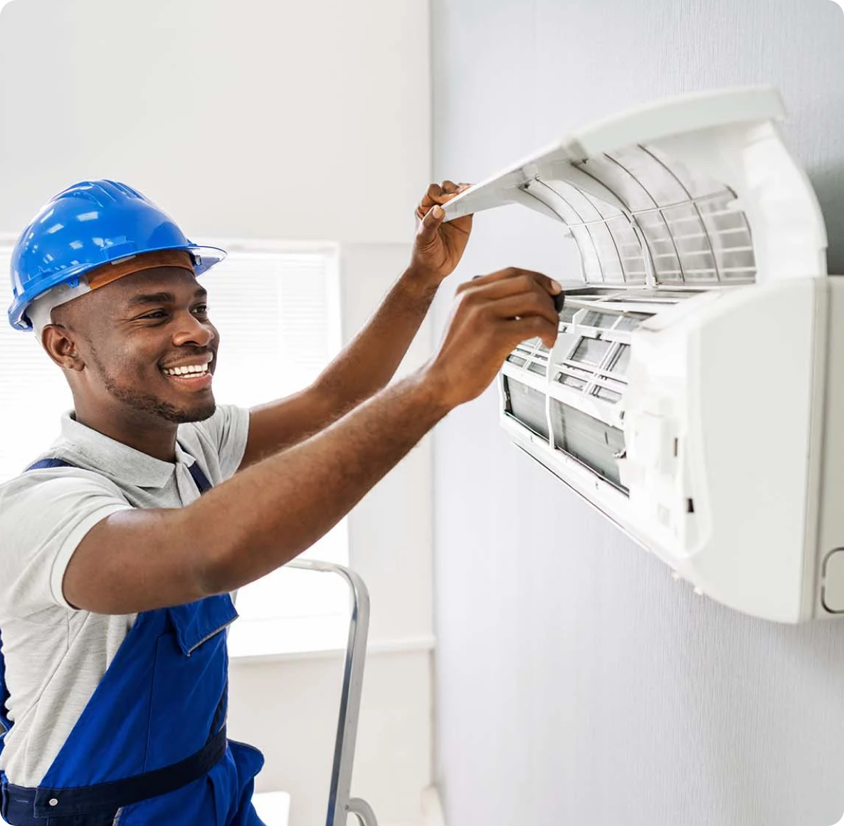 An HVAC tech working on a wall unit
