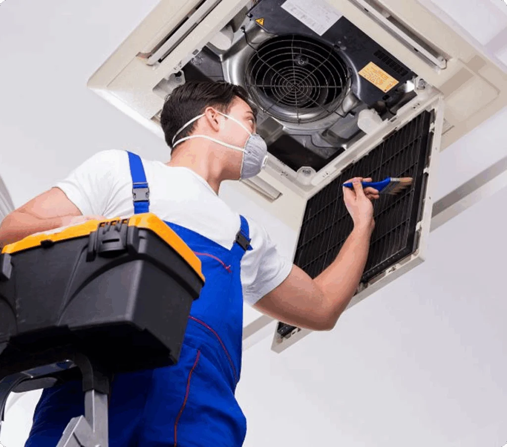 Technician inspecting a ceiling-mounted air conditioning unit