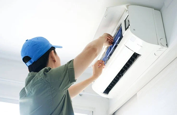 A tech preforming HVAC maintenance