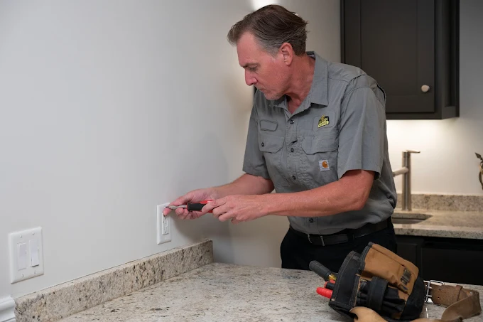 An electrician working on an outlet
