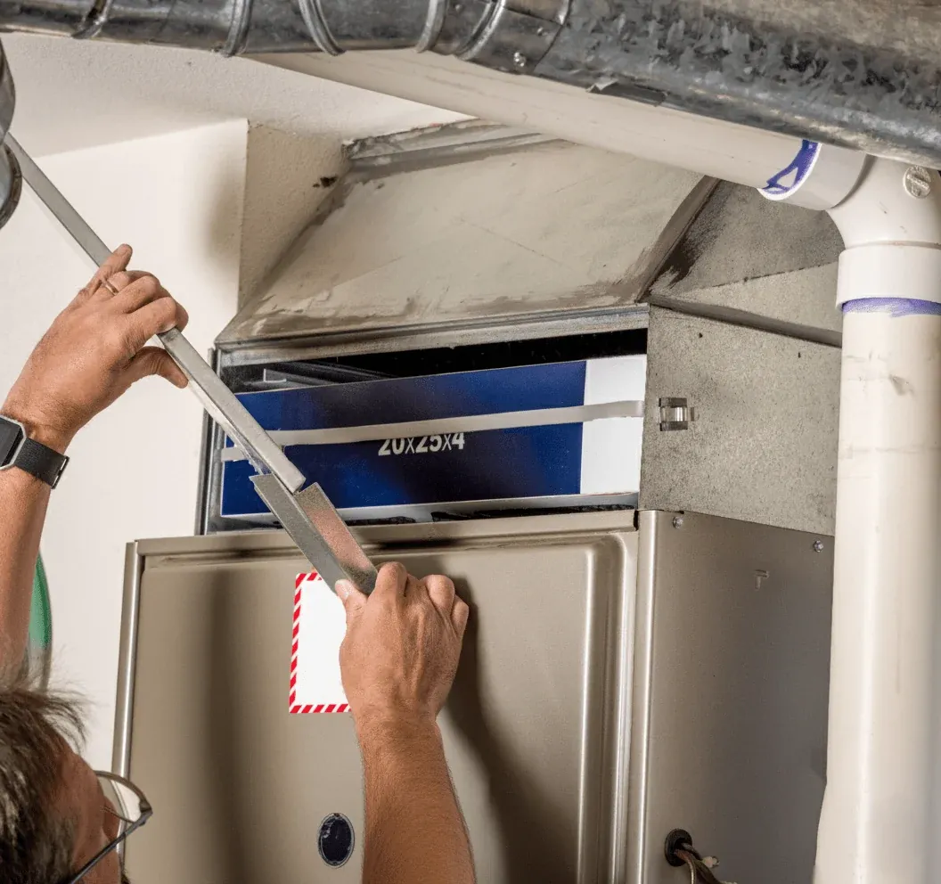 Technician replacing a furnace air filter