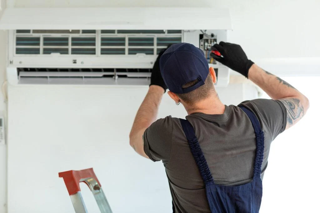 Technician servicing a wall-mounted ductless air conditioner