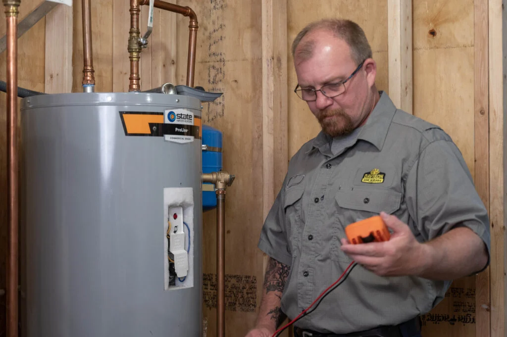 Davison technician checking a water heater with a handheld meter