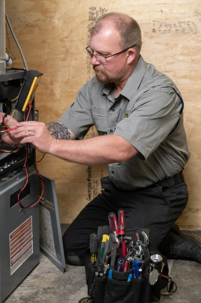 Davison technician checking wiring inside HVAC equipment