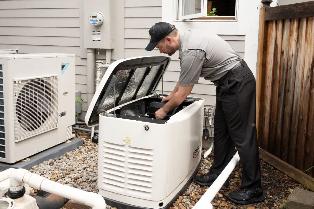 Davison technician servicing an outdoor HVAC unit with its cover open