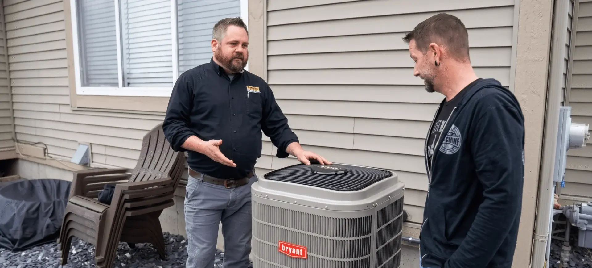 Two technicians discussing an outdoor air conditioner